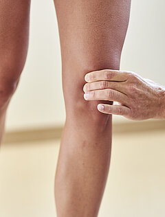 Untersuchung des Kniegelenks einer Patientin der orthopädischen Reha